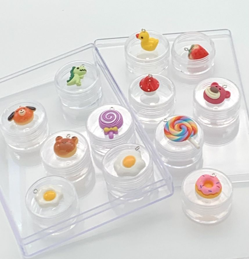 Have' em all: 12 cute Toy Charms in a box, starring dino, duck. Beer, dog, frog, donut, strawberry, lollipop rainbow,lollipop purple, sunny side up egg small, Sunny side up egg medium, mushroom